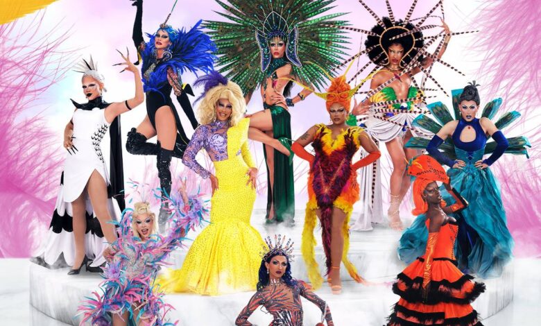 A imagem apresenta um grupo de drag queens em um cenário vibrante e colorido. Elas estão vestidas com trajes elaborados e extravagantes, cada uma com um estilo único. O fundo é decorado com elementos festivos e coloridos, criando uma atmosfera de celebração. No topo da imagem, está o título