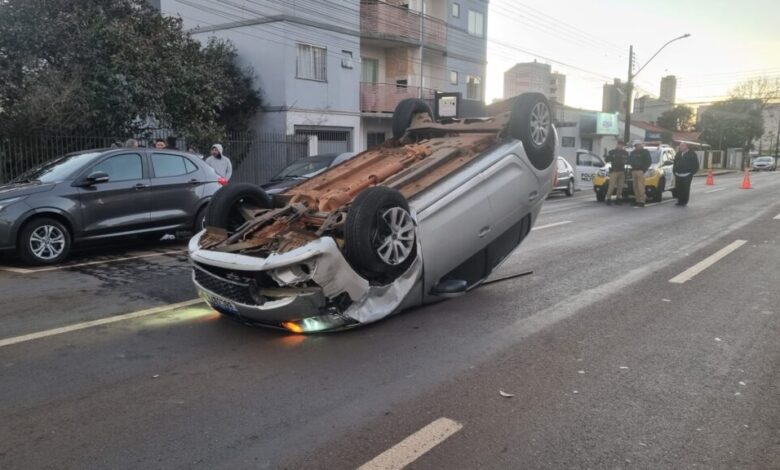 Sandero capota após bater em dois carros estacionados na Rua Presidente Kennedy
